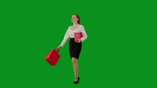 現代のビジネス女性 クロマキーグリーンスクリーンの魅力的なオフィスガールの肖像画 スカートとブラウスの女性は 紙のフォルダと赤いギフト紙袋で歩いています ハーフターン — ストック動画