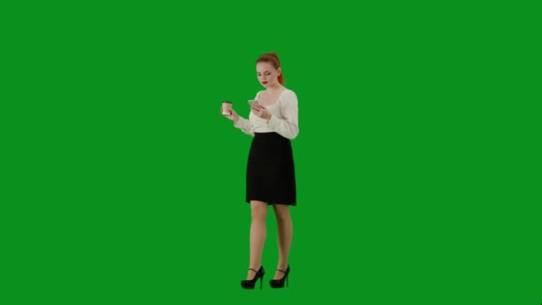 現代のビジネス女性 クロマキーグリーンスクリーンの魅力的なオフィスガールの肖像画 スカートの女性とカップからコーヒーを飲んで歩くブラウス スマートフォンでテキスト ハーフターン — ストック動画