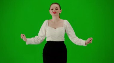Modern iş kadını yaratıcı reklam konsepti. Krom anahtar yeşil ekranda çekici ofis kızı portresi. Etek ve bluz giymiş bir kadın kameraya bakarak tatlı tatlı dans ediyor..