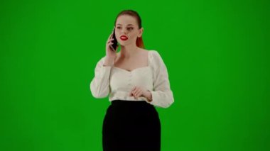 Modern iş kadını yaratıcı reklam konsepti. Krom anahtar yeşil ekranda çekici ofis kızı portresi. Etek ve bluz giyen bir kadın akıllı telefondan konuşuyor, pozitif yüz ifadesi..