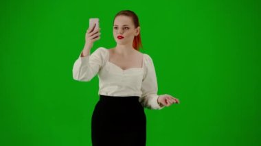 Modern iş kadını yaratıcı reklam konsepti. Krom anahtar yeşil ekranda çekici ofis kızı portresi. Etek giyen bir kadın akıllı telefonuyla konuşuyor, mutlu bir ifade..