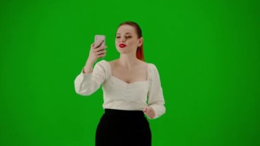 Modern iş kadını yaratıcı reklam konsepti. Krom anahtar yeşil ekranda çekici ofis kızı portresi. Etek giyen bir kadın akıllı telefonuyla konuşuyor, mutlu bir ifade..