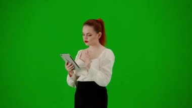 Modern iş kadını yaratıcı reklam konsepti. Krom anahtar yeşil ekranda çekici ofis kızı portresi. Etekli ve bluzlu bir kadın elinde tabletle yürüyor. Yarım dönüş..