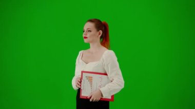 Modern iş kadını yaratıcı reklam konsepti. Krom anahtar yeşil ekranda çekici ofis kızı portresi. Etekli ve bluzlu bir kadın kırmızı klasör tutarak yürüyor. Yarım dönüş..