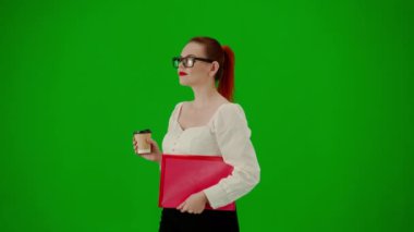 Modern iş kadını yaratıcı reklam konsepti. Krom anahtar yeşil ekranda çekici ofis kızı portresi. Kırmızı klasör ve kahve fincanı tutan etekli ve gözlüklü bir kadın. Yarım dönüş..