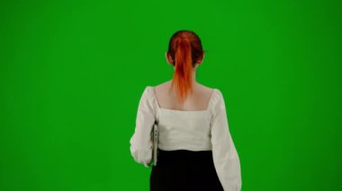 Modern iş kadını yaratıcı reklam konsepti. Krom anahtar yeşil ekranda çekici ofis kızı portresi. Etekli ve bluzlu bir kadın elinde dizüstü bilgisayarla yürüyor. Arka plan.