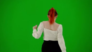 Modern iş kadını yaratıcı reklam konsepti. Krom anahtar yeşil ekranda çekici ofis kızı portresi. Etek ve bluz giymiş bir kadın kurnazca dans ediyor. Arka plan.