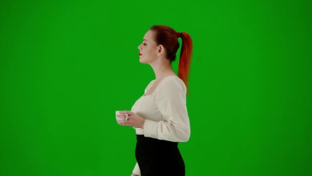 现代商业女性 色键绿色屏幕上漂亮的办公室女孩的肖像 穿着短裙和衬衫的女人 面带微笑地走着 喝着杯子里的咖啡 侧视图 — 图库视频影像