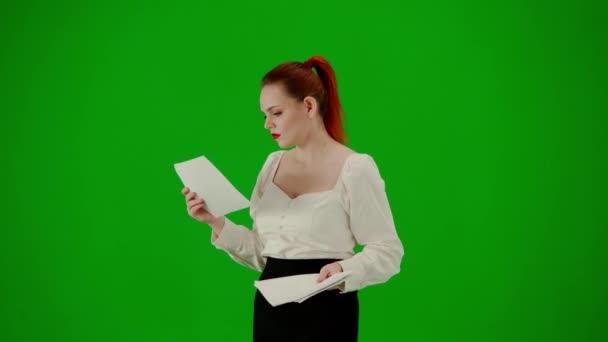 现代商业女性 色键绿色屏幕上漂亮的办公室女孩的肖像 身着短裙和女衫的女人一边走路一边阅读纸质文件 一边专注地表现自己的面部表情 转半圈 — 图库视频影像