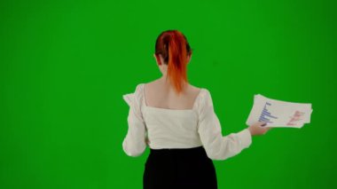 Modern iş kadını yaratıcı reklam konsepti. Krom anahtar yeşil ekranda çekici ofis kızı portresi. Etekli ve bluzlu bir kadın gazete okuyarak yürüyor. Arka plan.