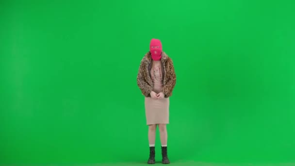 穿着粉色巴拉克拉瓦 虎皮大衣和晚礼服的女人弹跳着 挥动着胳膊 工作室里的女人都是绿色背景的时尚潮流的概念 时尚中的女权主义趋势 — 图库视频影像