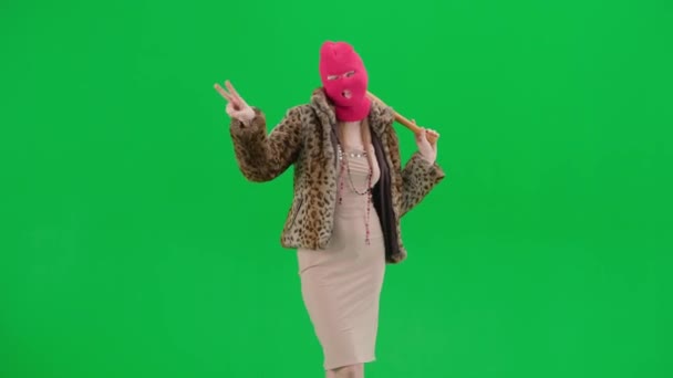 ピンクのバラバラの女性 タイガーのコート 夜のドレスは勝利のジェスチャーを示しています スタジオの緑色の背景にバットを手に入れたフリークな女性 ファッショントレンドコンセプト ファッションにおけるフェミニストのトレンド — ストック動画