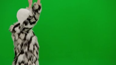 Beyaz ve pembe kar maskeli iki kadın neşeyle yürüyor ve dans ediyor. Yeşil stüdyo arka planında kürk giyen ucube kadınlar. Moda eğilimi, feminist moda eğilimi