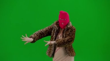 Pembe kar maskeli kadın, kaplan kürkü ve akşam elbisesi zarif bir şekilde dans eden oryantal dans. Stüdyoda yeşil bir geçmişi olan ucube bir kadın. Moda eğilimi, feminist moda eğilimi