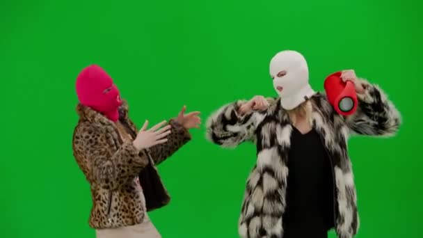 两个身穿白色和粉色光环的女人欢快地跳舞 穿着皮毛外套的女人穿着绿色工作室背景的衣服 时尚潮流的概念 时尚中的女权主义趋势 — 图库视频影像
