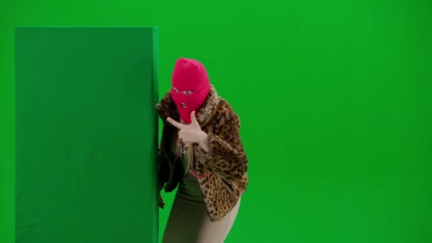 ピンクのバラカバラの女性 タイガーコート ドレスは緑色のバナーの後ろから飛び出し 指を指差してジェスチャーを見せます スタジオで緑の背景にフリーク女性 — ストック動画