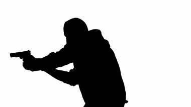 İzole edilmiş beyaz arka planda siyah bir hırsız silueti. Kapüşonlu ve kar maskeli bir erkek soyguncu elinde bir silahla suç işlemeye hazırlanıyor. Yarım dönüş.