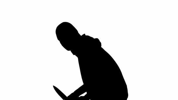 独立的白色背景上的小偷的黑色轮廓 一个穿着帽衫和巴拉克拉瓦的男性抢劫犯手里拿着刀走着 准备犯罪 侧视图 — 图库视频影像