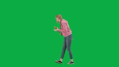 Soygun ve ceza konsepti. Krom anahtar yeşil ekranda kurbanın portresi. Yalnız yürüyen genç kız, korkmuş yüz ifadesi, elinde beyzbol sopası, etrafa bakınıyor. Yarım dönüş.