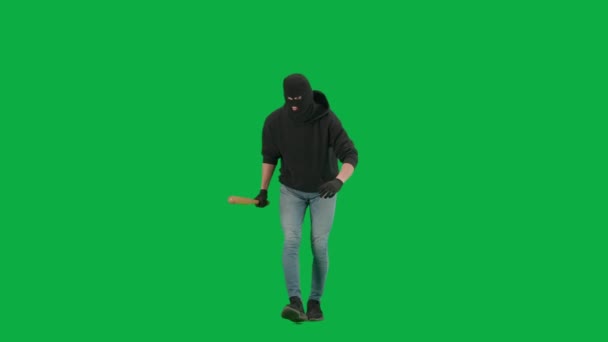 強盗と犯罪概念 クロマキーグリーンの背景に泥棒の肖像画 バラバラの男強盗とフーディー 手で野球バットを保持して歩く — ストック動画