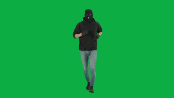 強盗と犯罪概念 クロマキーグリーンの背景に泥棒の肖像画 フーディー ジーンズ 黒いバラバラを身に着けている男強盗 犯罪の準備をしている — ストック動画