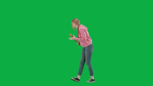 強盗と犯罪概念 クロマキーの緑色の背景の犠牲者の肖像画 一人で歩いている若い女の子 怖い顔の表情 野球バットを持って周りを見回します ハーフターン — ストック動画