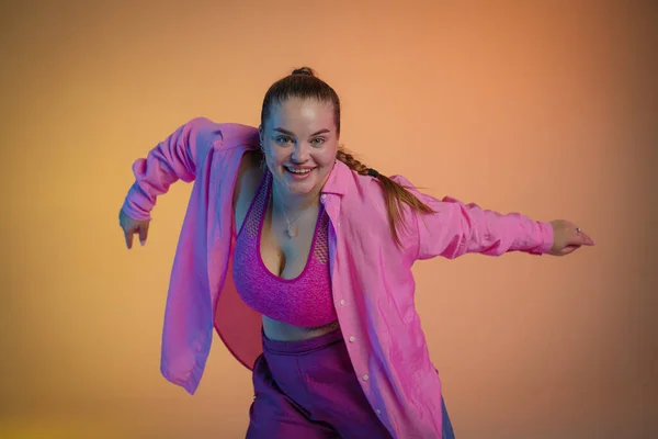 Ung Kvinna Rosa Skjorta Poserar Mot Orange Studiobakgrund Dansaren Demonstrerar — Stockfoto