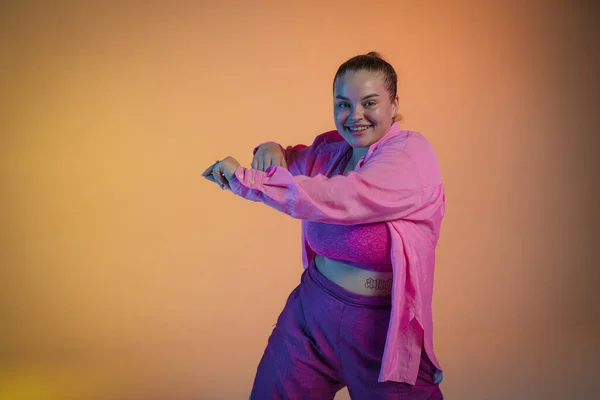 Vor Der Kulisse Eines Orangefarbenen Studios Tanzt Eine Junge Frau — Stockfoto