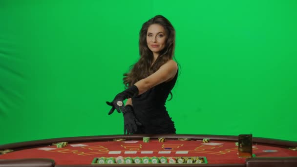 赌场和赌博创意广告的概念 彩色键绿色屏幕上的女性肖像 身着连衣裙的女人站在21点扑克桌旁 指着镜头前的桌子 慢动作 — 图库视频影像