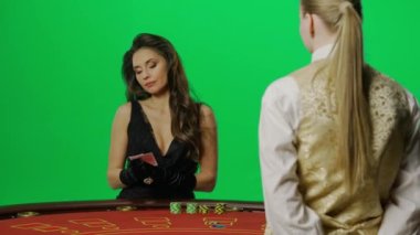 Kumarhane ve kumar yaratıcı reklam konsepti. Krom anahtar yeşil ekranda zarif bir kadın portresi. Blackjack poker masasında elinde kartlarla çekici bir kadın var. Krupiye bir kart veriyor.