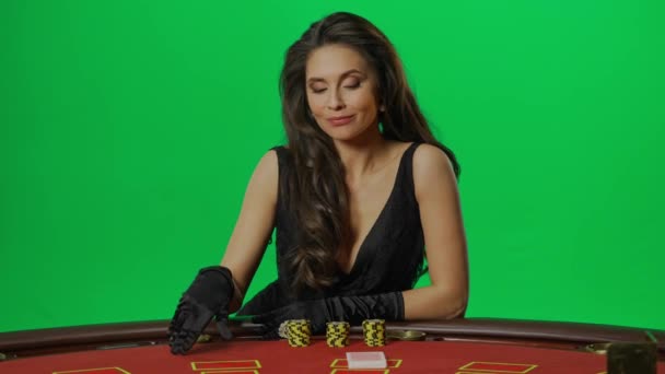 赌场和赌博创意广告的概念 彩色键绿色屏幕上的女性肖像近景 优雅的女人坐在21点扑克牌桌旁滑动卡片 慢动作 — 图库视频影像