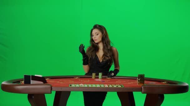 カジノとギャンブルクリエイティブ広告コンセプト クロマキーグリーンでエレガントな女性の肖像画 魅力的な女性プレーヤーは チップを作る賭けを置くブラックジャックポーカーテーブルに立っています — ストック動画
