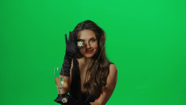 カジノとギャンブルクリエイティブ広告コンセプト クロマキーグリーンスクリーンのエレガントな女性の肖像画が閉じます シャンパンのチップとガラスをポーズするブラックジャックポーカーテーブルに立っている女性 — ストック動画