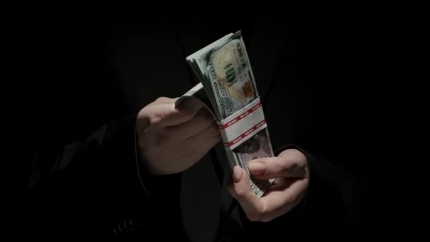ビジネスとマネーのクリエイティブ広告コンセプト 黒いバックグラウンドで隔離された黒いスーツの女性の肖像画 ドル紙幣を握っている女性の手は フリッピング 閉じる — ストック動画
