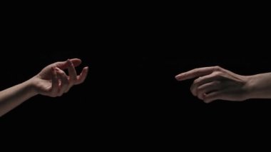 Vücut parçaları estetik güzellik ve cilt kreatif reklam konsepti. Stüdyoda siyah arka planda izole edilmiş kadın modelin portresi. Birbirlerine uzanan çıplak iki kadın parmaklarına dokunur..