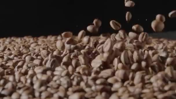 褐色咖啡豆在黑色的背景上摇曳着 在空中飞舞 烘烤或冷却咖啡豆的过程 咖啡店或餐馆的广告概念 — 图库视频影像