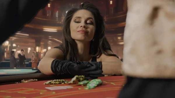 カジノでブラックジャックゲームのためのポーカーテーブルで黒いドレスで魅力的な女性 女性はすべてのチップで最大の賭けを賭けています カジノとギャンブルの概念 — ストック写真