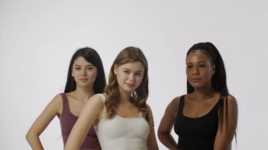 Doğal güzellik ve çeşitlilik reklam konsepti. Beyaz arka planda izole edilmiş çok ırklı kadın modellerin portresi, yakın çekim. Üç tane çok ırklı kız birlikte poz veriyor. Çoklu Etnik