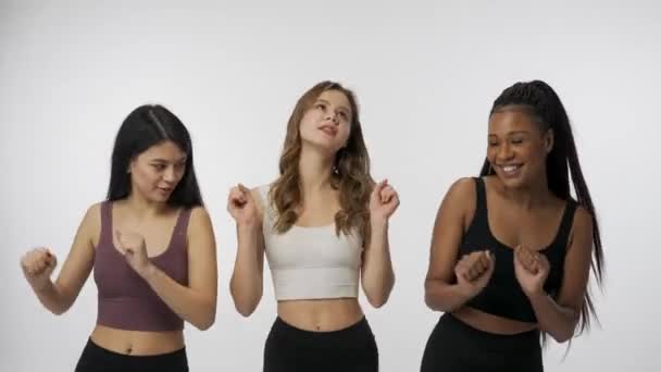 自然美と多様性の広告コンセプト ホワイトスタジオのバックグラウンドに若い多民族モデルの肖像画が閉じられました カメラで幸せに踊る3人の美しい多民族少女のグループ — ストック動画