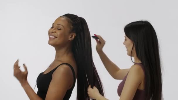 自然美と多様性の広告コンセプト 白い背景に隔離された多民族モデルの肖像画 クローズショット カメラで髪を和らげる2人の若い多人種の少女のグループ — ストック動画
