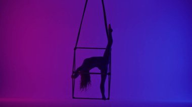 Modern koreografi ve akrobasi yaratıcı reklam konsepti. Kadın akrobatın silueti neon arka planda izole edildi. Kadın akeralist dansçı iplerle havada yarıklar açıyor..