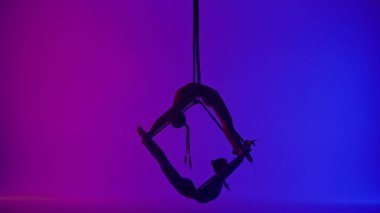 Modern koreografi ve akrobasi yaratıcı reklam konsepti. Neon arka planda izole edilmiş iki kadın akrobatın silueti. Kız akrobat dansçılar iplerle havada yarık açıyorlar..