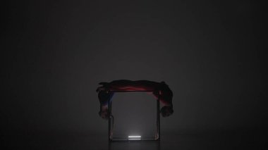 Modern koreografi ve akrobasi yaratıcı reklam konsepti. Siyah arka planda izole edilmiş iki kadın akrobatın portresi. Mavi elbiseli kızlar küp içinde poz veriyorlar..