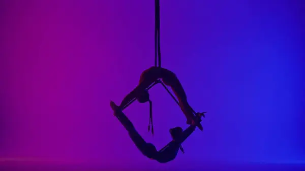 现代编舞和杂技创意广告的概念 两名在霓虹灯背景下被隔离的女杂技演员的轮廓 女空想家们在空中用绳子在立方体上旋转着 — 图库照片