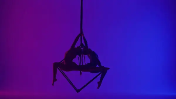 现代编舞和杂技创意广告的概念 两名在霓虹灯背景下被隔离的女杂技演员的轮廓 女空想家们在空中用绳子在立方体上旋转着 — 图库照片