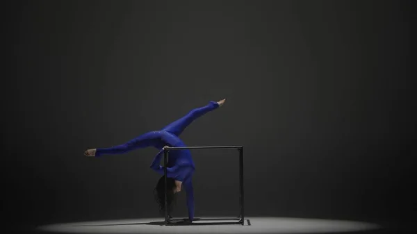 Modern choreography and acrobatics creative advertisement concept. Portrait of female acrobat isolated on black background. Woman gymnastic dancer in blue sparkling bodysuit performing on a cube.