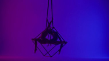 Modern koreografi ve akrobasi yaratıcı reklam konsepti. Neon arka planda izole edilmiş iki kadın akrobatın silueti. Kız akrobat dansçılar iplerle havada yarık açıyorlar..