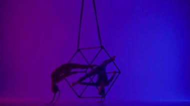 Modern koreografi ve akrobasi yaratıcı reklam konsepti. Neon arka planda izole edilmiş iki kadın akrobatın silueti. Kız akrobat dansçılar iplerle havada yarık açıyorlar..