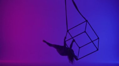 Modern koreografi ve akrobasi yaratıcı reklam konsepti. Kadın akrobatın silueti neon arka planda izole edildi. Kadın akeralist dansçı iplerle havada yarıklar açıyor..