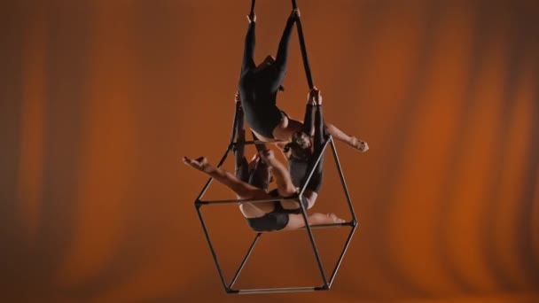 現代の振付とアクロバットクリエイティブ広告コンセプト オレンジ色の背景に隔離された女性のアクロバットの肖像画 女の子空想家ダンサー ロープとキューブで空中に回転トリオ — ストック動画